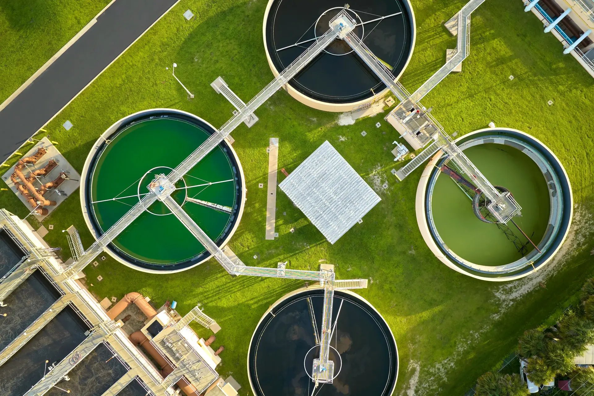 Aerial top-down view of circular sedimentation tanks at a municipal water treatment plant.