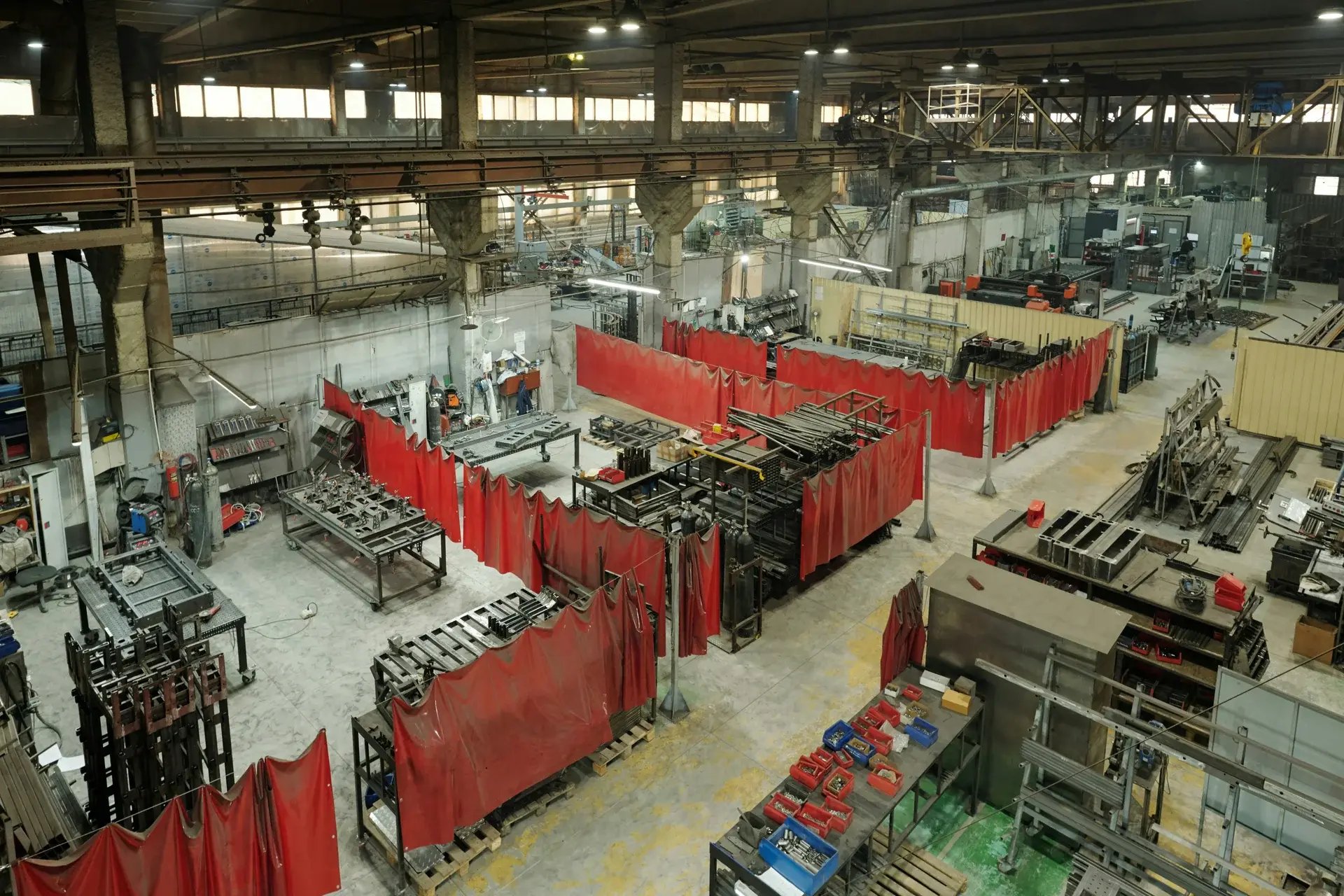 Overhead view of an industrial metal fabrication shop with welding bays.