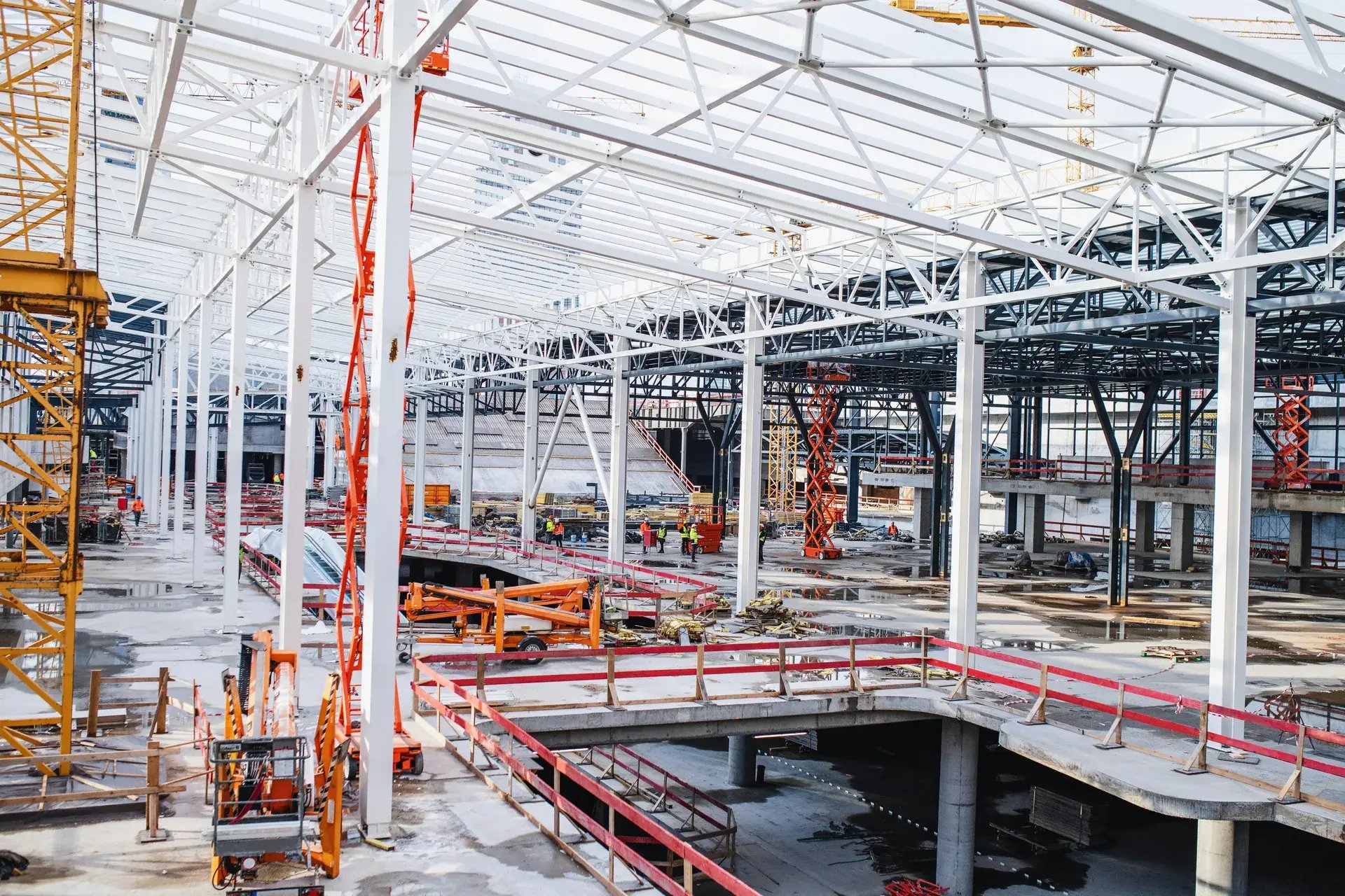 Wide interior view of a large commercial construction site showing steel framework.